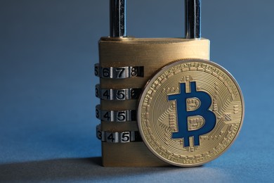 Photo of Bitcoin and padlock on color background, closeup