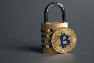Photo of Bitcoin and padlock on grey background, closeup. Space for text