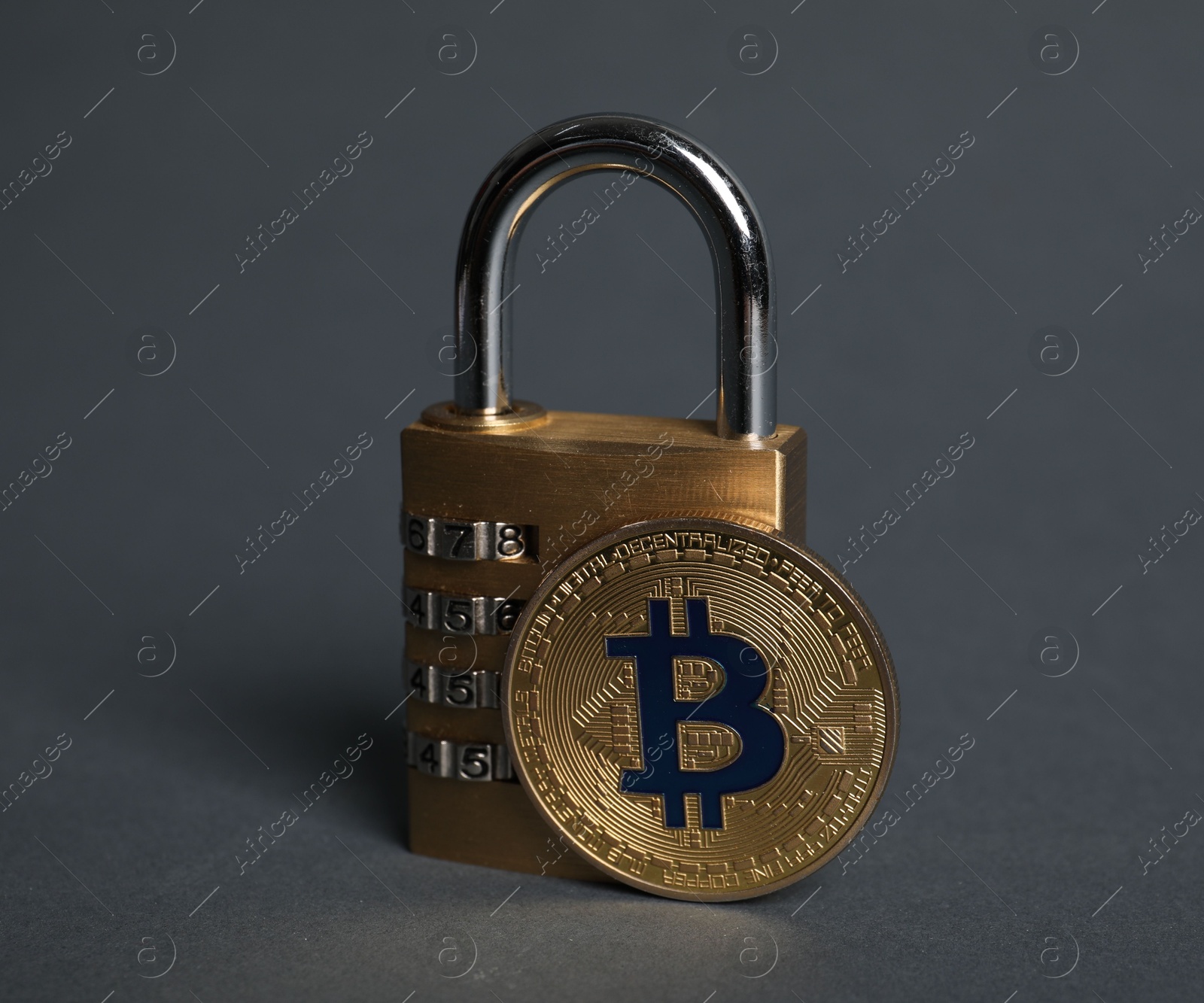 Photo of Bitcoin and padlock on grey background, closeup