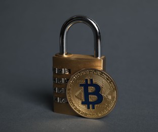 Photo of Bitcoin and padlock on grey background, closeup