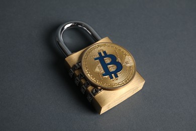Photo of Bitcoin and padlock on grey background, closeup