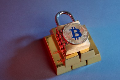 Photo of Bitcoin, padlock and gold bars on color background in red light, closeup