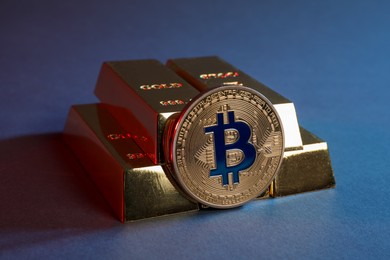Photo of Bitcoin and gold bars on color background, closeup