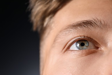 Photo of Man with beautiful eyes on black background, closeup