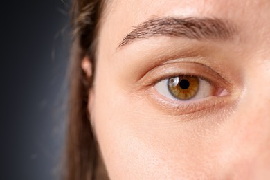 Photo of Woman with beautiful eyes on grey background, closeup