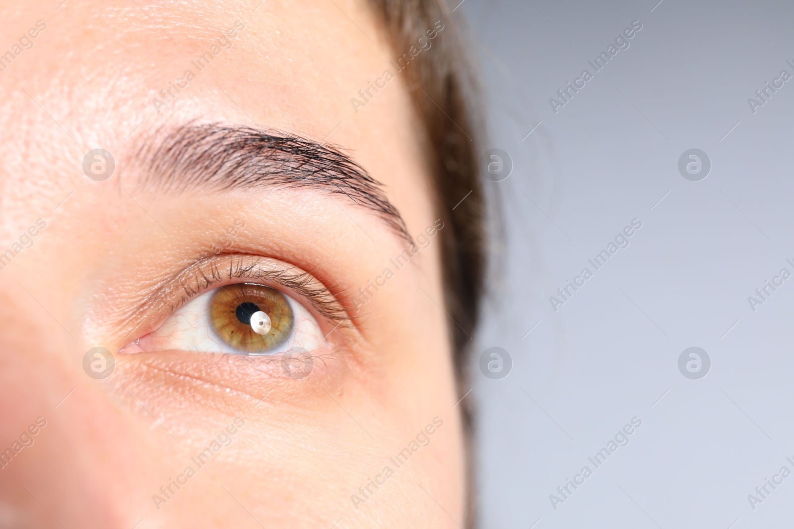 Photo of Woman with beautiful eyes on light grey background, closeup. Space for text