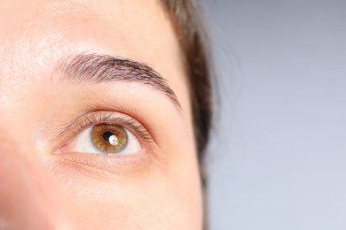 Photo of Woman with beautiful eyes on light grey background, closeup. Space for text