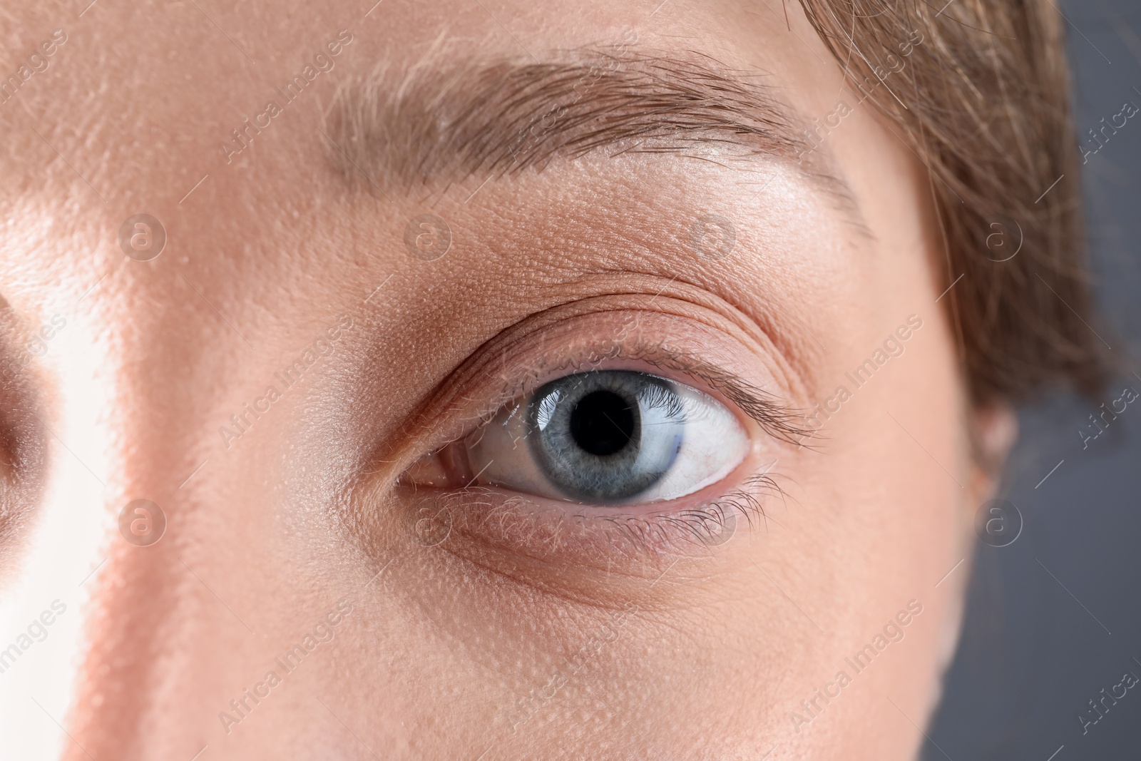 Photo of Woman with beautiful eyes on grey background, closeup
