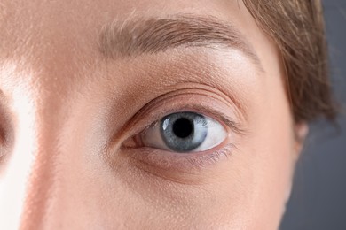 Photo of Woman with beautiful eyes on grey background, closeup