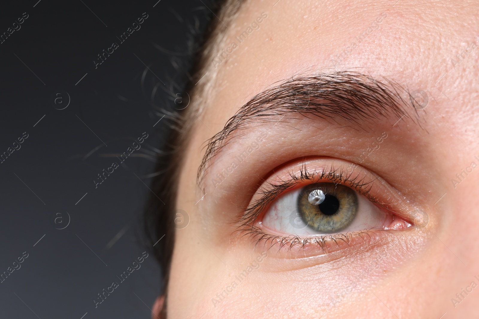 Photo of Woman with beautiful eyes on grey background, closeup. Space for text
