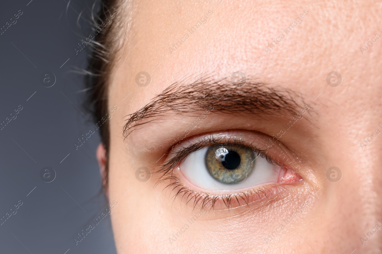 Photo of Woman with beautiful eyes on grey background, closeup