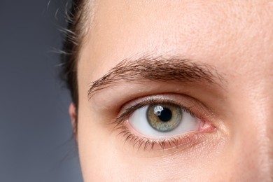 Photo of Woman with beautiful eyes on grey background, closeup