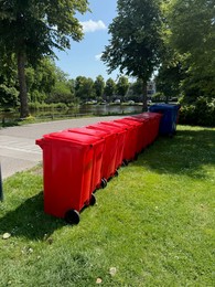 Photo of Many color trash bins on green grass in park