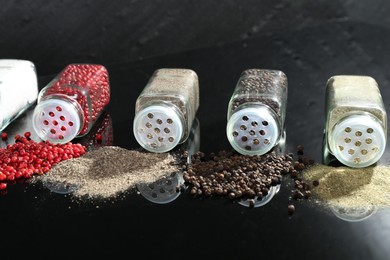 Photo of Different spices and glass jars on mirror surface, closeup