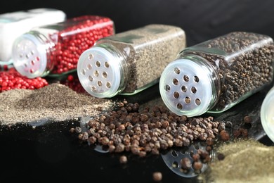 Photo of Different spices and glass jars on mirror surface, closeup
