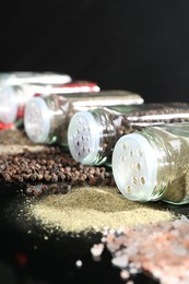 Photo of Different spices and glass jars on mirror surface, closeup