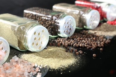 Photo of Different spices and glass jars on mirror surface, closeup