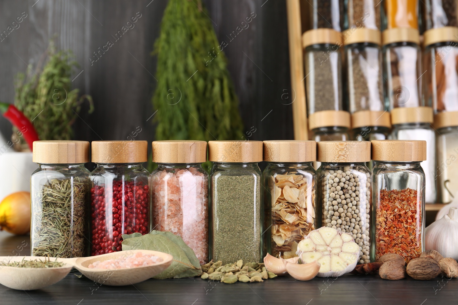 Photo of Different spices and glass jars on grey wooden table