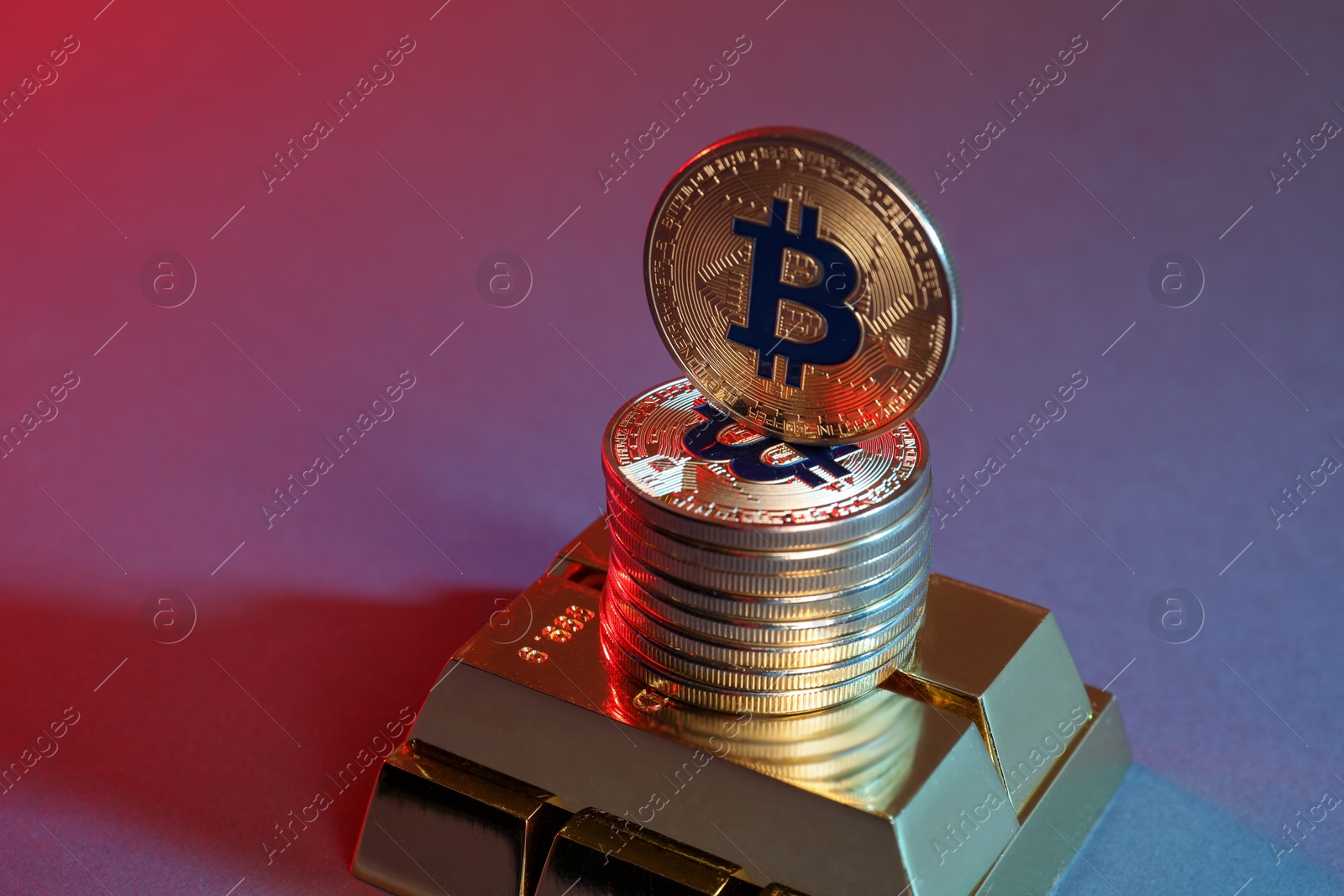 Photo of Bitcoins and gold bars on color background in red light, closeup