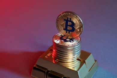 Photo of Bitcoins and gold bars on color background in red light, closeup