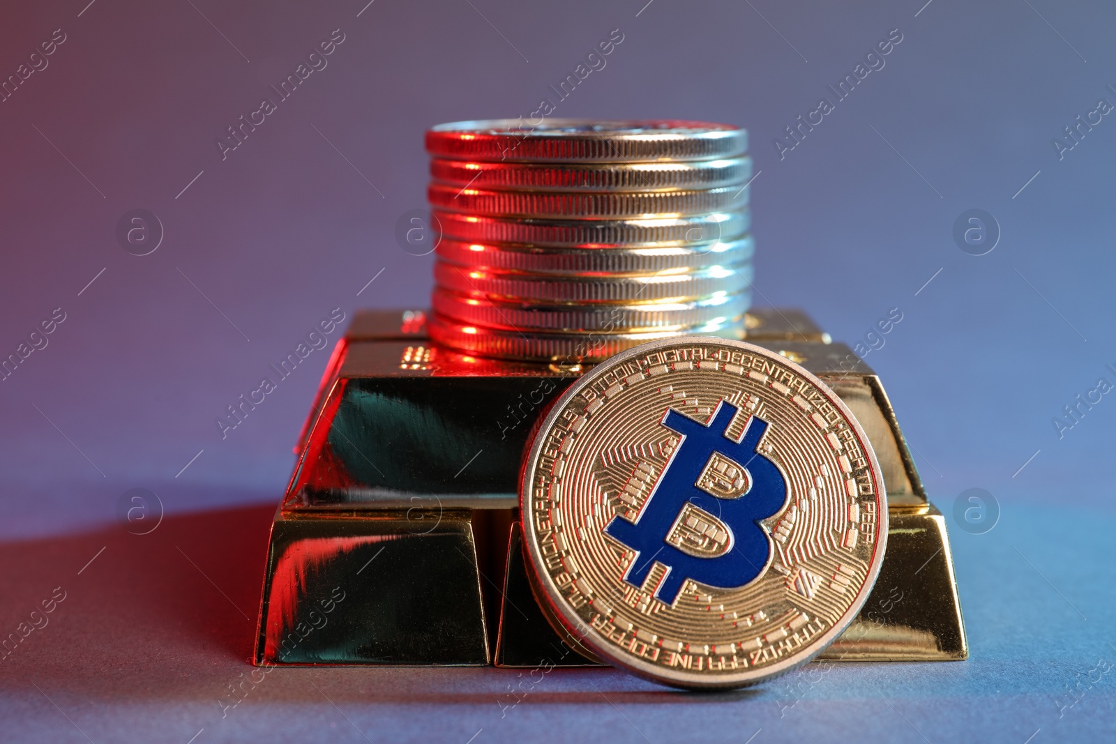 Photo of Bitcoins and gold bars on color background in red light, closeup