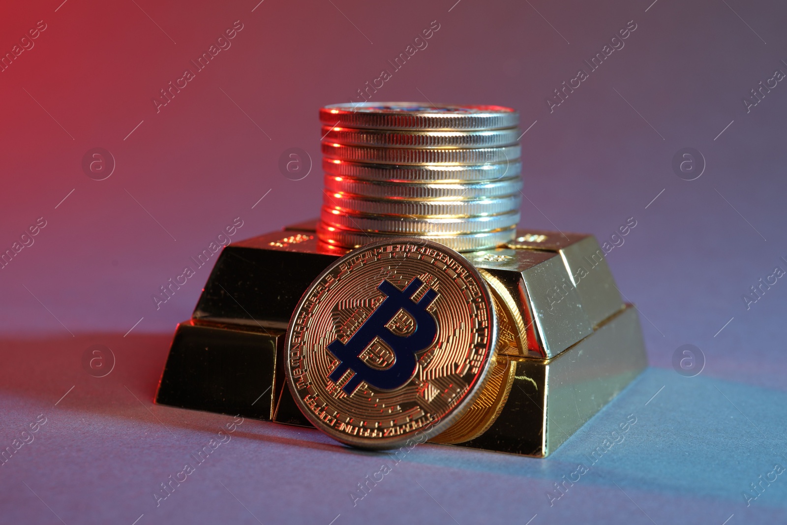 Photo of Bitcoins and gold bars on color background in red light, closeup
