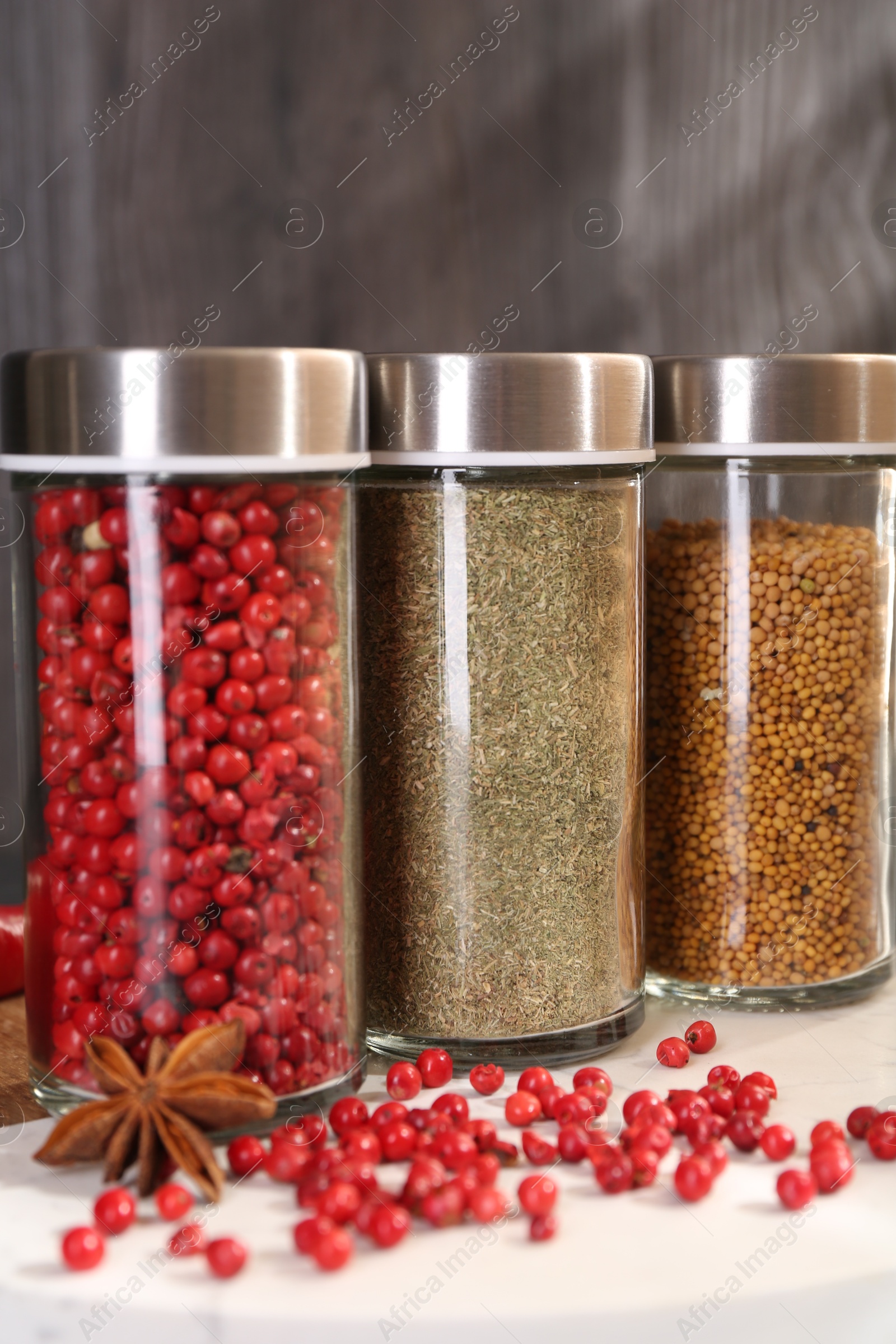 Different spices and glass jars on board, closeup Photo of Different spices and glass jars on board, closeup