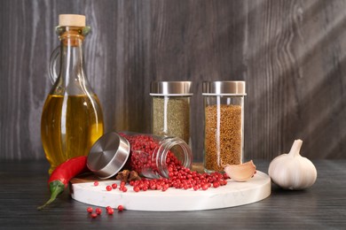 Photo of Different spices and glass jars on grey wooden table