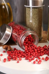 Photo of Different spices and glass jars on board, closeup