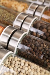 Photo of Different spices in glass jars as background, closeup