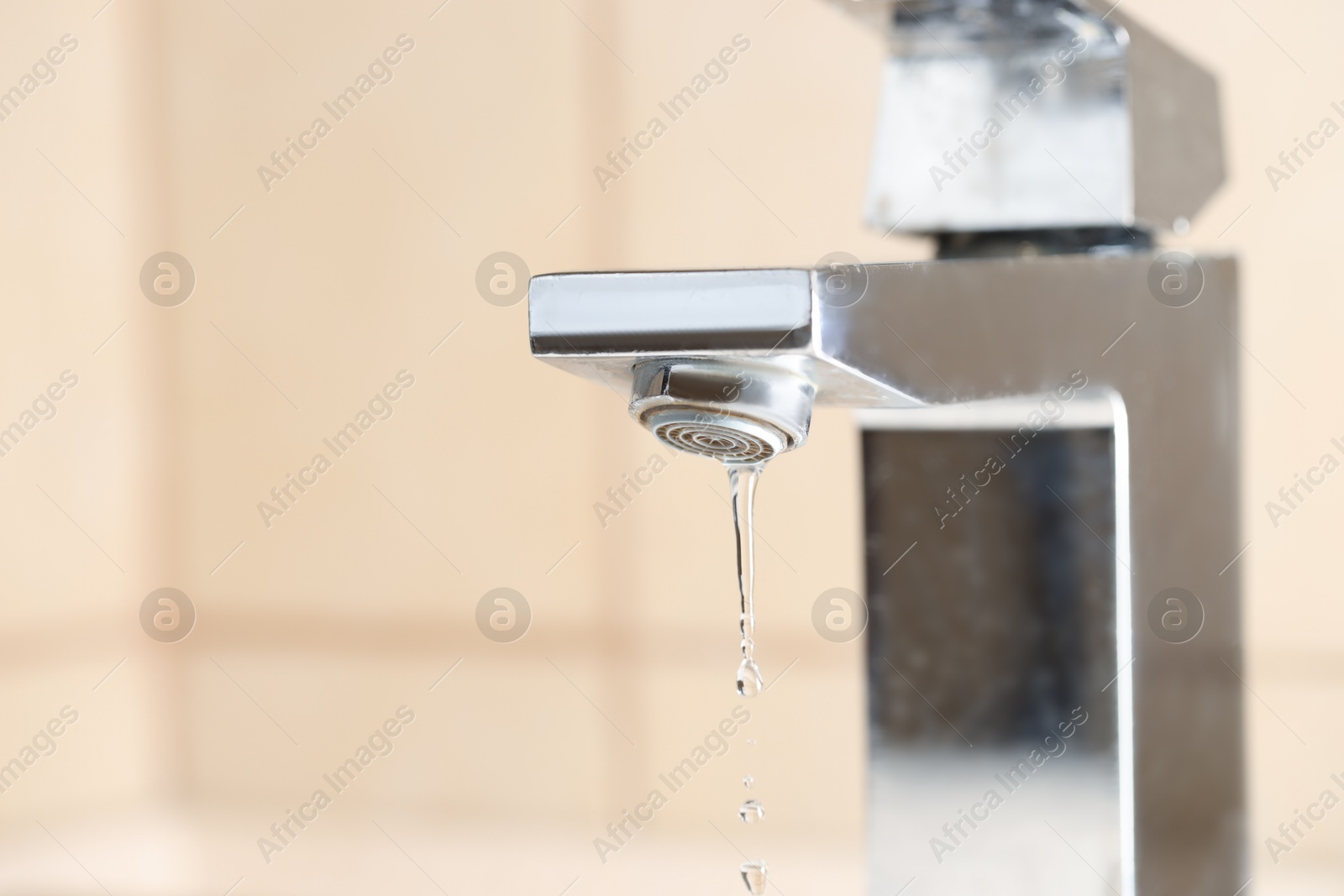 Photo of Water saving concept. Water dripping from tap indoors, closeup. Space for text