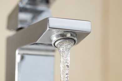 Photo of Water saving concept. Stream of water flowing from tap indoors, low angle view