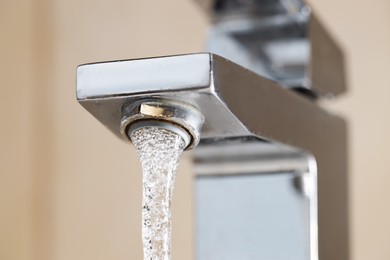 Photo of Water saving concept. Stream of water flowing from tap indoors, low angle view