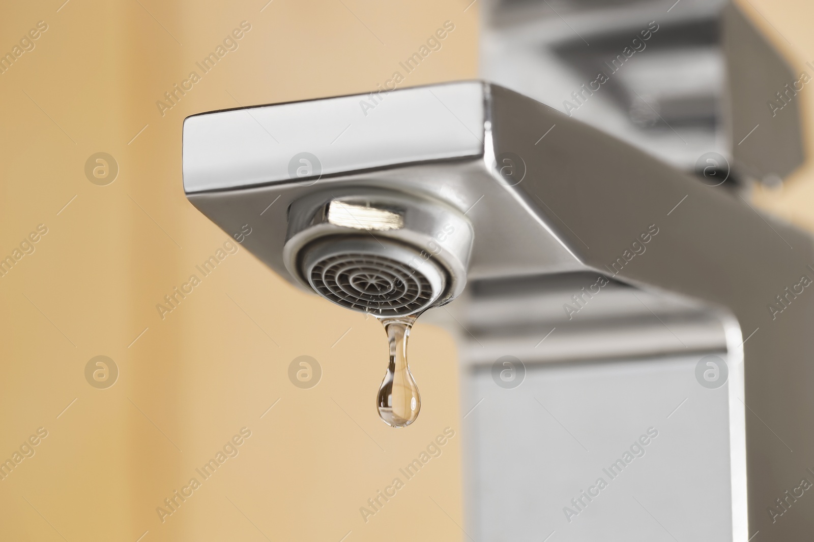 Water saving concept. Water dripping from tap indoors, low angle view Photo of Water saving concept. Water dripping from tap indoors, low angle view