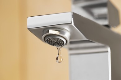 Photo of Water saving concept. Water dripping from tap indoors, low angle view