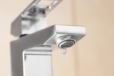 Photo of Water saving concept. Water dripping from tap indoors, low angle view
