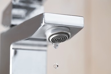 Photo of Water saving concept. Water dripping from tap indoors, low angle view