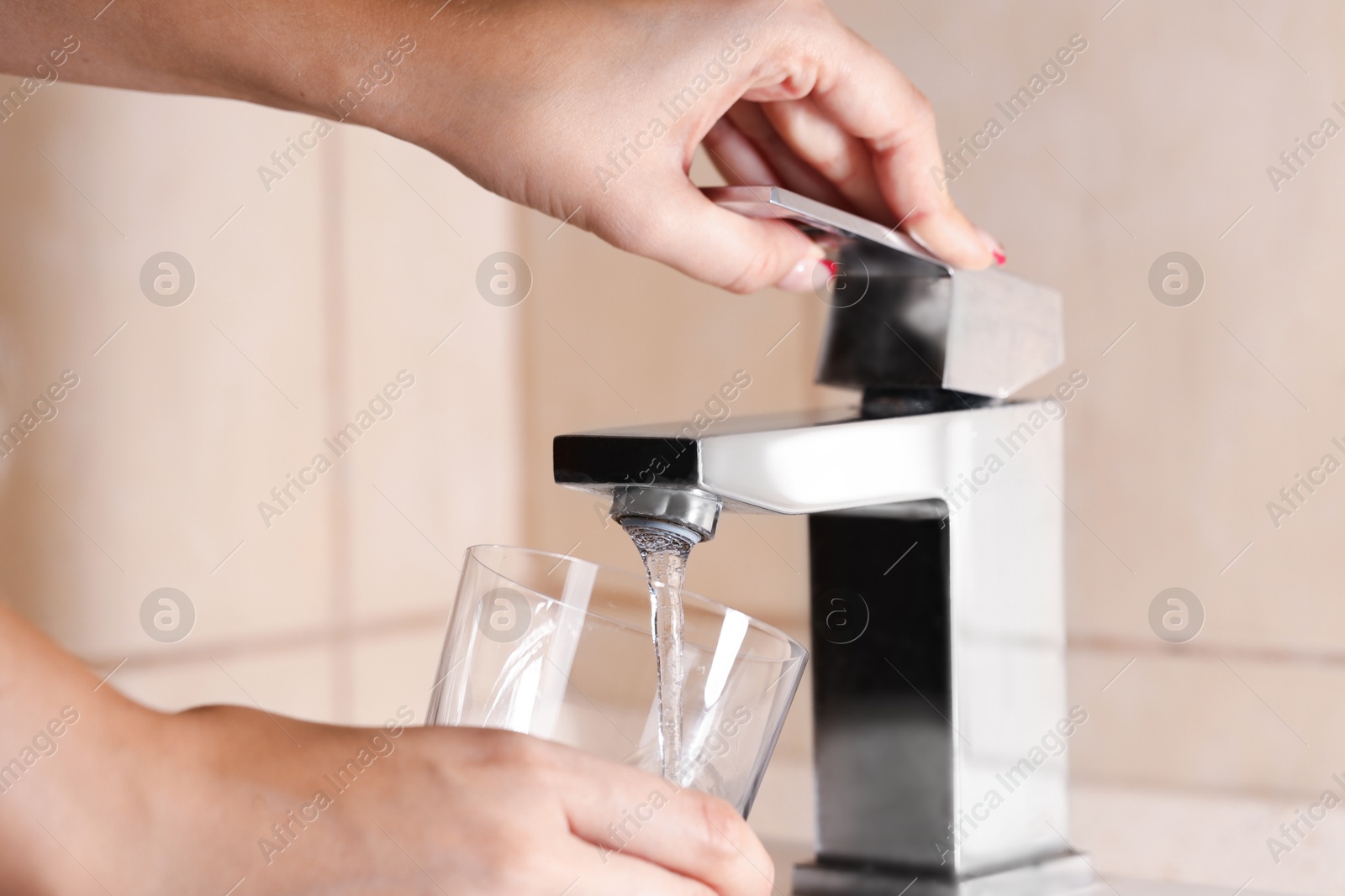 Photo of Water saving concept. Woman filling glass with tap water indoors, closeup