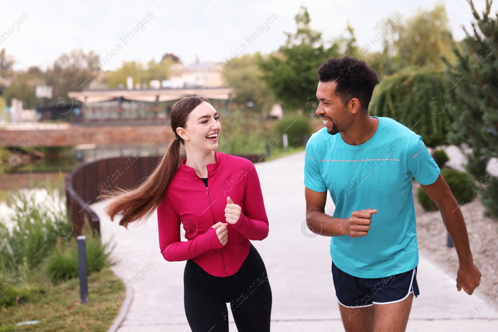 Photo of Happy couple in sportswear running outdoors. Healthy lifestyle