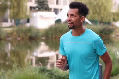 Photo of Handsome man running outdoors. Space for text