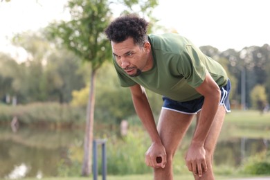 Photo of Handsome man resting after run outdoors. Space for text