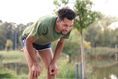 Photo of Smiling man resting after run outdoors. Healthy lifestyle