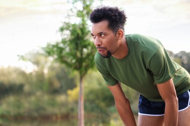Photo of Handsome man resting after run outdoors. Space for text