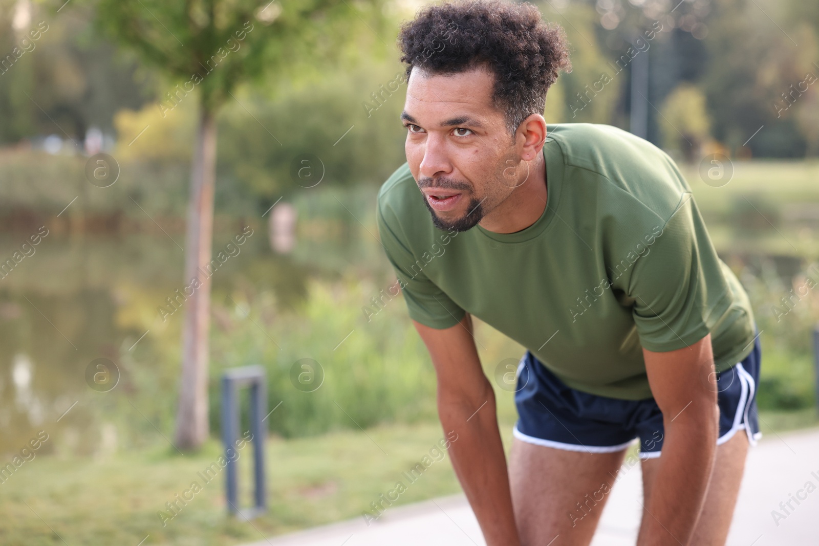Photo of Handsome man resting after run outdoors. Space for text
