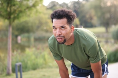 Photo of Handsome man resting after run outdoors. Space for text
