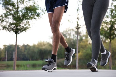 Photo of Couple running outdoors, closeup. Space for text