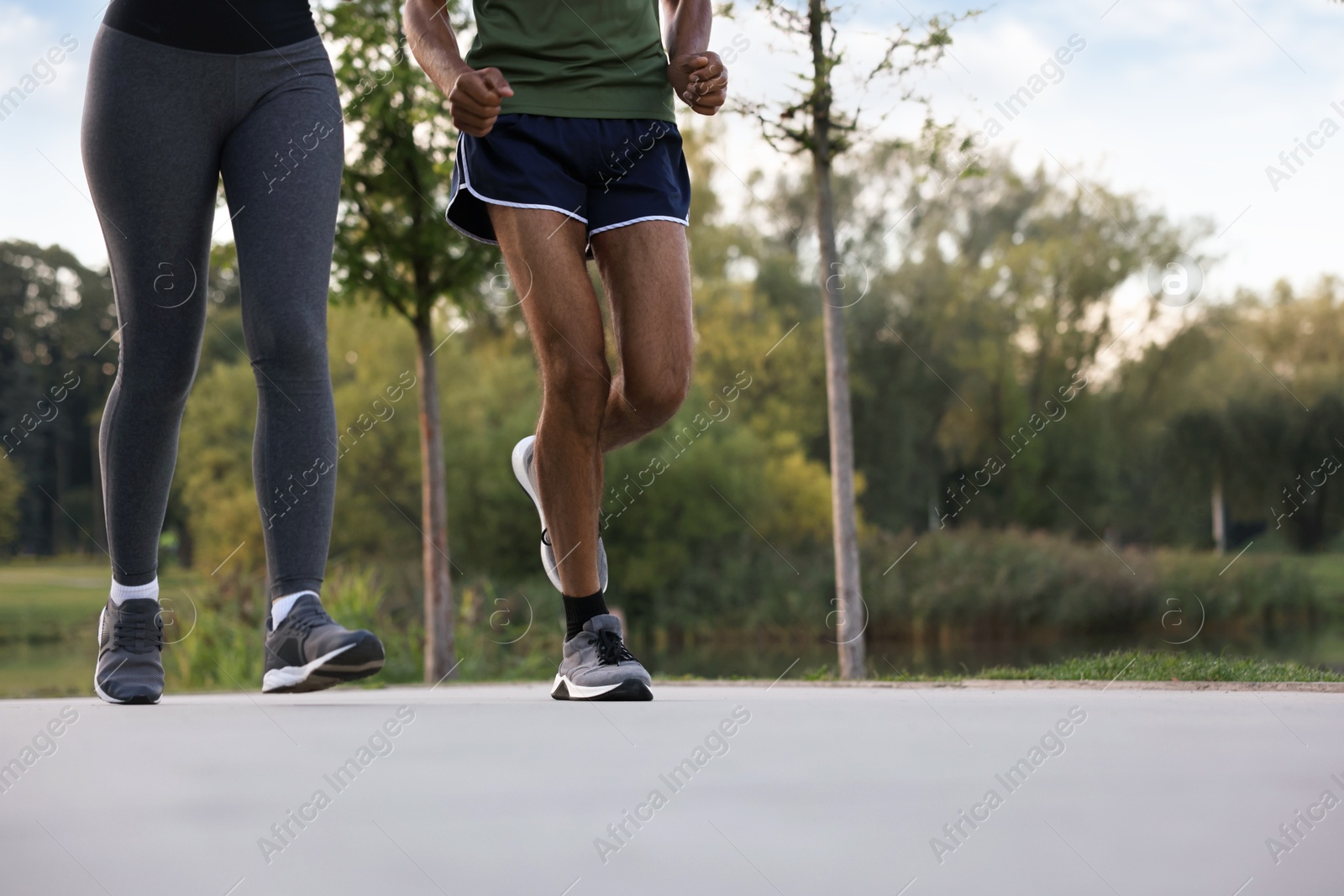 Couple running outdoors, closeup. Space for text Photo of Couple running outdoors, closeup. Space for text