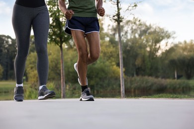 Photo of Couple running outdoors, closeup. Space for text