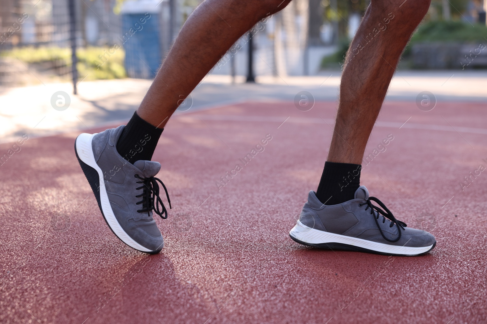 Photo of Man in sneakers running at stadium, closeup
