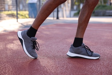 Photo of Man in sneakers running at stadium, closeup